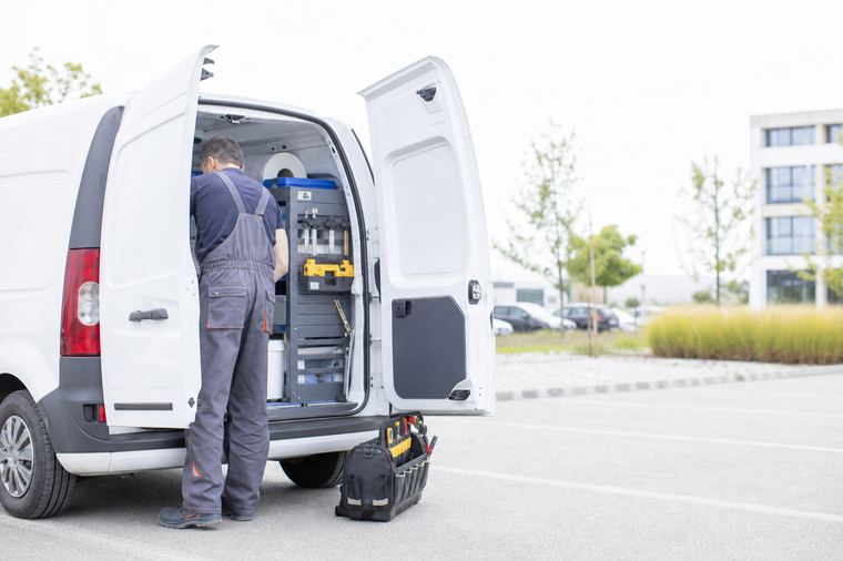 Furgone Volkswagen Transporter di colore verde acqua parcheggiato lungo il marciapiede di una via cittadina